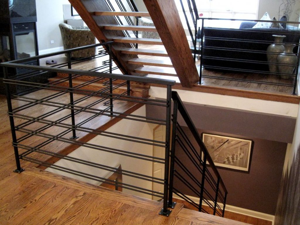 A staircase featuring sleek metal railings and warm wood floors, creating a stylish and inviting atmosphere.