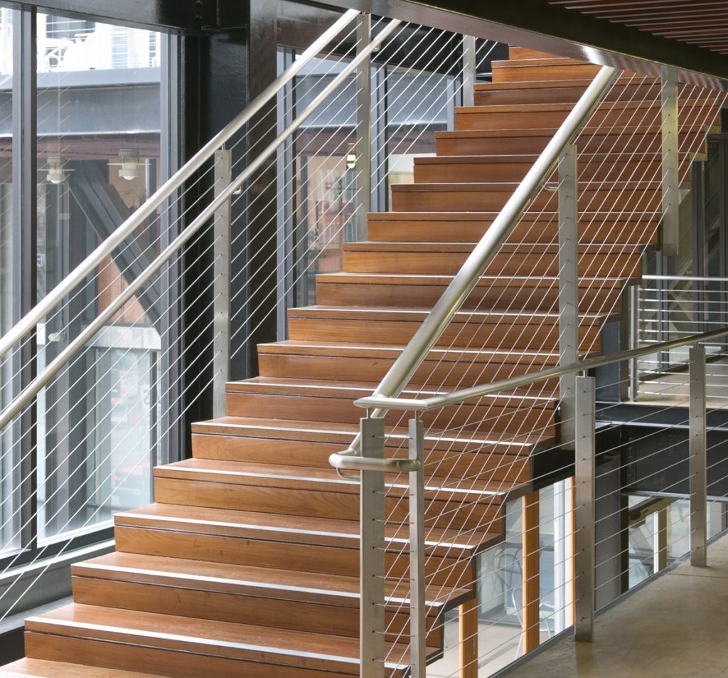 A staircase featuring sleek metal railings and warm wooden steps, creating a stylish and inviting atmosphere.